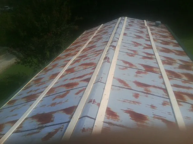 Rusted metal roof panels with new wood purlins before replacement — Storm Damage Roof Repair in Mc Clelland by Roofing Brothers